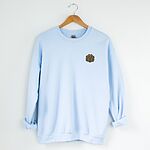 Light Blue crewneck sweatshirt on a hanger, embroidered with a small golden doodle face on the left chest