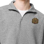 Person in a heather grey quarter zip over a white T-shirt, embroidered with a golden doodle face on the left chest