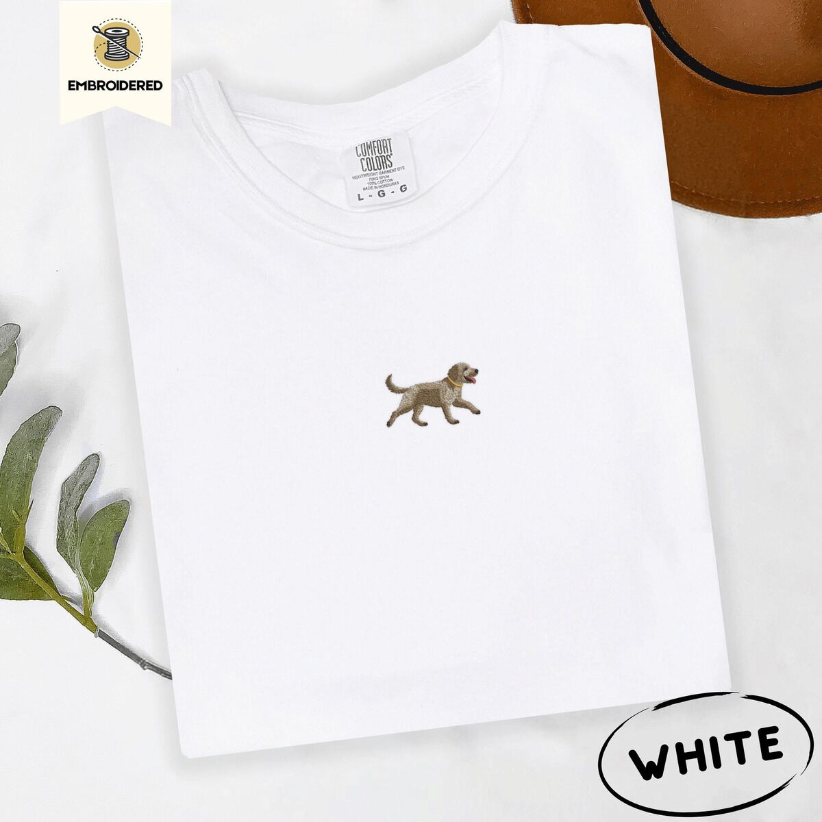 Goldendoodle T-Shirt – White White Comfort Colors T-shirt embroidered with a mini apricot goldendoodle trotting in a gold collar with its tongue out, in the center of the chest