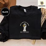 Black crewneck sweatshirt with a brown felt hat and dried bunny tail grass, embroidered with a cool white goose in black sunglasses with arched white lettering embroidered on the chest