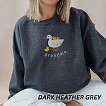 Woman wearing a Dark Heather crewneck sweatshirt embroidered with a white mama duck, yellow ducklings and the word grandma in white thread