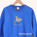 Royal blue crewneck sweatshirt on a wooden hanger, embroidered with a white mama duck, yellow ducklings and the word grandma in white thread