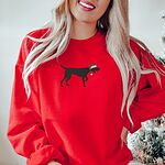 Woman by a Christmas tree in a Red crewneck sweatshirt embroidered with a black German shorthaired pointer silhouette in a red Santa hat
