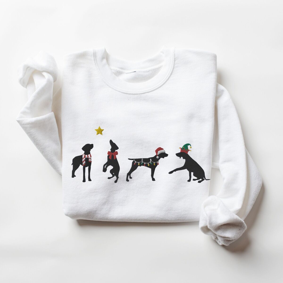 GSP Silhouette Christmas Sweatshirt - White White crewneck sweatshirt laid flat on a white background, embroidered with four black German shorthaired pointer silhouettes in a striped scarf, a red bow, Christmas lights, a Santa hat and an elf hat under a gold star