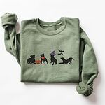 Military Green crewneck sweatshirt laid flat on a white background, embroidered with four black pit bull silhouettes with a jack-o'-lantern, an orange bandana, a purple witch hat and bats