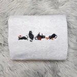 Holiday cat sweatshirt in light heather grey with four embroidered black cats, a Santa hat, Christmas lights, a gift box and ornaments