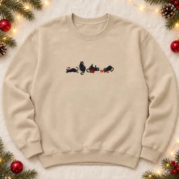 Sand holiday cat sweatshirt with four embroidered black cats, a Santa hat, Christmas lights, a gift box and ornaments across the chest