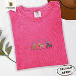 Crunchberry Comfort Colors T-shirt embroidered with three horses in Santa hats, a red scarf and red leg wraps trotting under turquoise snowflakes