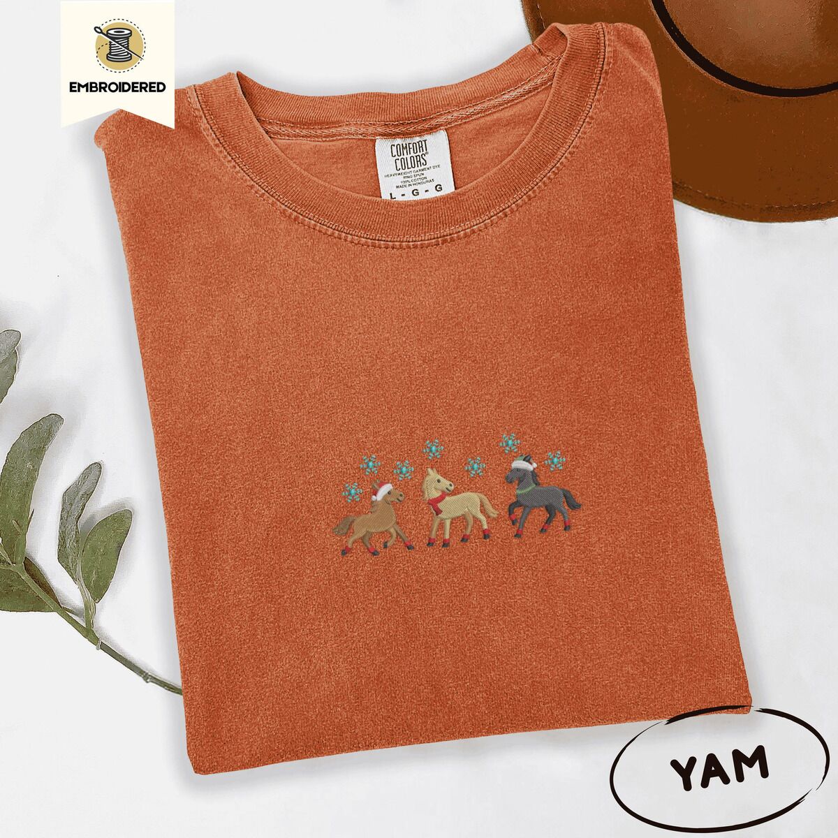 Horse Christmas Shirt – Yam Yam Comfort Colors T-shirt embroidered with three horses in Santa hats, a red scarf and red leg wraps trotting under turquoise snowflakes