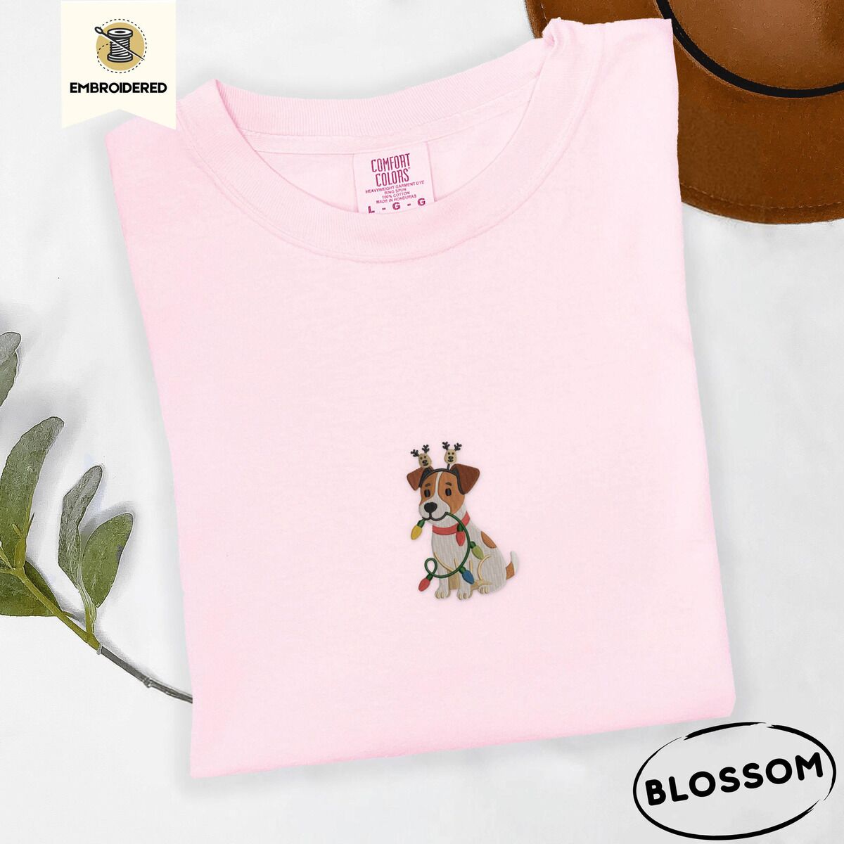 Jack Russell Christmas Lights Shirt – Blossom Blossom Comfort Colors T-shirt embroidered with a white and tan Jack Russell puppy in a reindeer headband chewing a string of Christmas lights