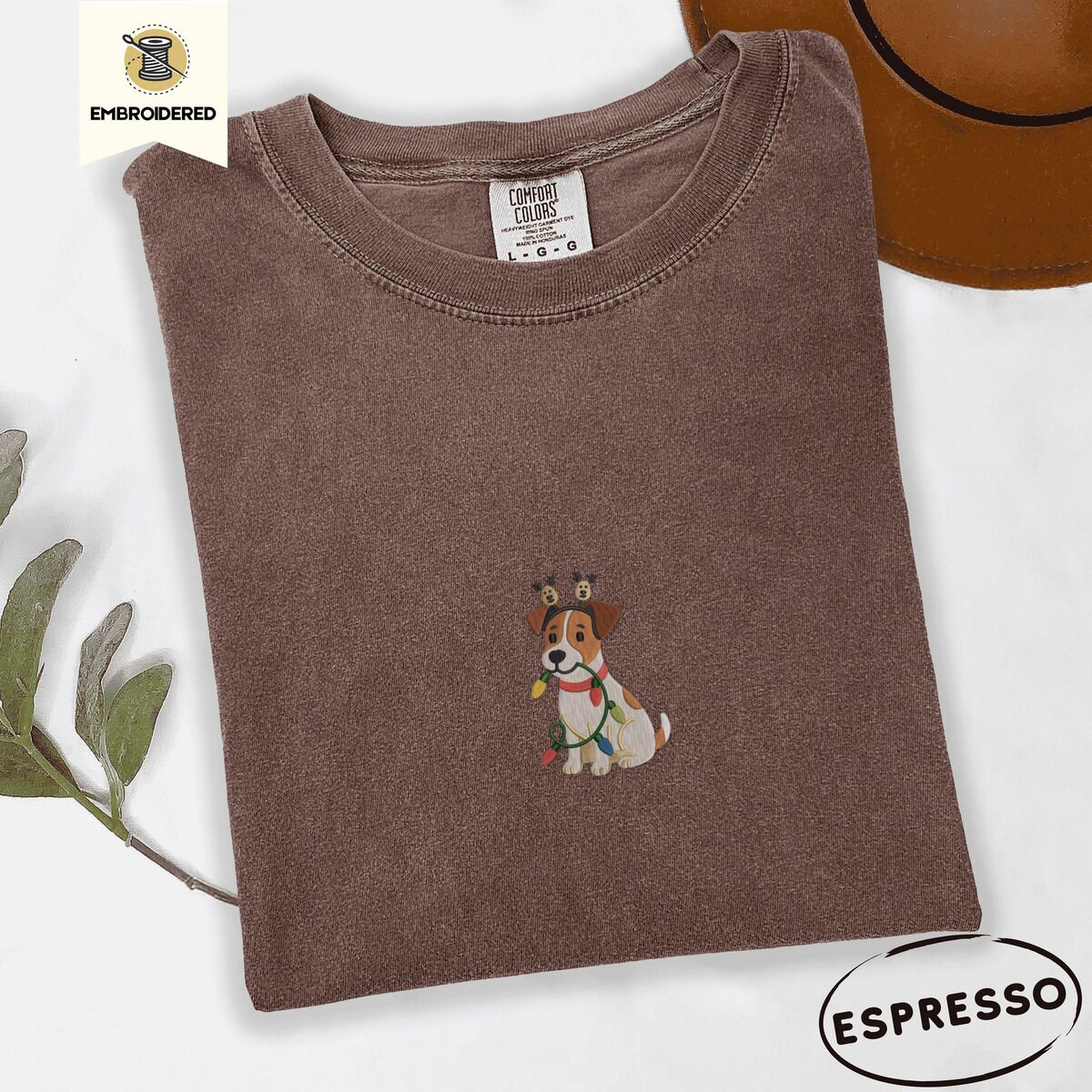 Jack Russell Christmas Lights Shirt – Espresso Espresso Comfort Colors T-shirt embroidered with a white and tan Jack Russell puppy in a reindeer headband chewing a string of Christmas lights