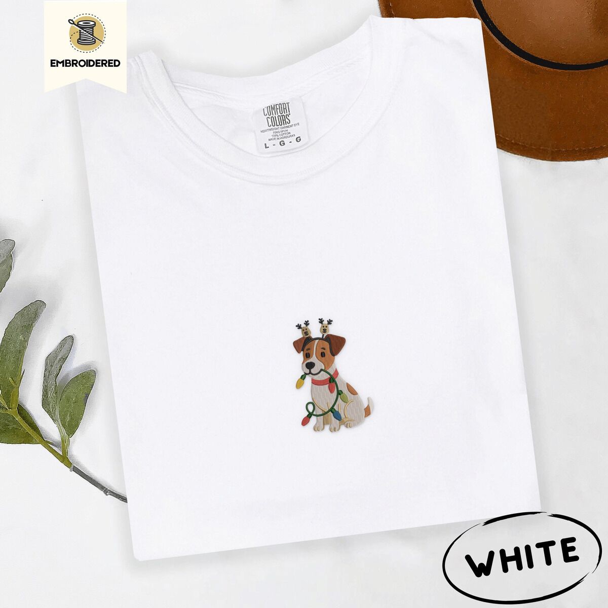 Jack Russell Christmas Lights Shirt – White White Comfort Colors T-shirt embroidered with a white and tan Jack Russell puppy in a reindeer headband chewing a string of Christmas lights