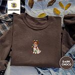 Dark Chocolate crewneck sweatshirt on a plaid flannel shirt with yellow autumn leaves and denim shorts, embroidered with a white and tan Jack Russell puppy in a reindeer headband chewing a string of Christmas lights