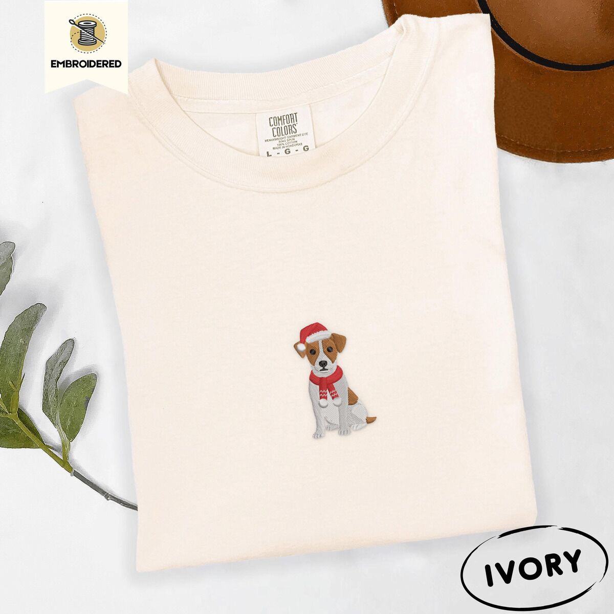 Jack Russell Santa Hat Shirt – Ivory Ivory Comfort Colors T-shirt embroidered with a mini Jack Russell Terrier puppy in a red Santa hat and a knitted red scarf