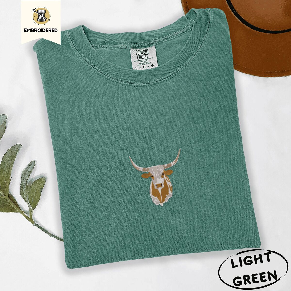 Longhorn Cow Shirt – Light Green Light Green Comfort Colors T-shirt embroidered with a copper and cream longhorn steer head with long curved horns