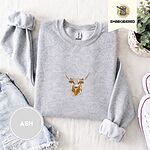 Ash crewneck sweatshirt folded with denim shorts, white sneakers and a potted plant, embroidered with a longhorn steer head with cream and copper patches and long curved horns