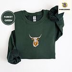 Forest Green crewneck sweatshirt folded on a white background, embroidered with a longhorn steer head with cream and copper patches and long curved horns