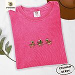 Crunchberry Comfort Colors T-shirt embroidered with three green-headed mallards in Santa hats, scarves and boots carrying a string of Christmas lights