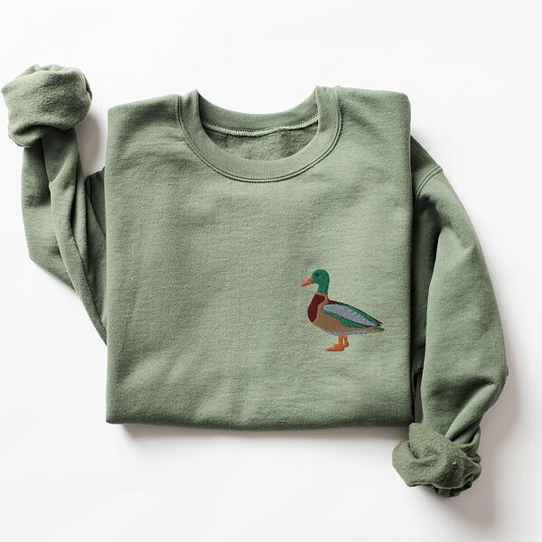 Mallard crewneck in Military Green laid flat with a rolled sleeve, embroidered with a standing drake mallard with a green head, orange bill, chestnut chest and grey wing on the left chest