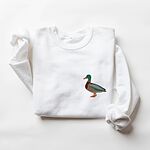 White crewneck sweatshirt laid flat with a rolled cuff, embroidered with a standing drake mallard with a green head, orange bill, chestnut chest and grey wing on the left chest