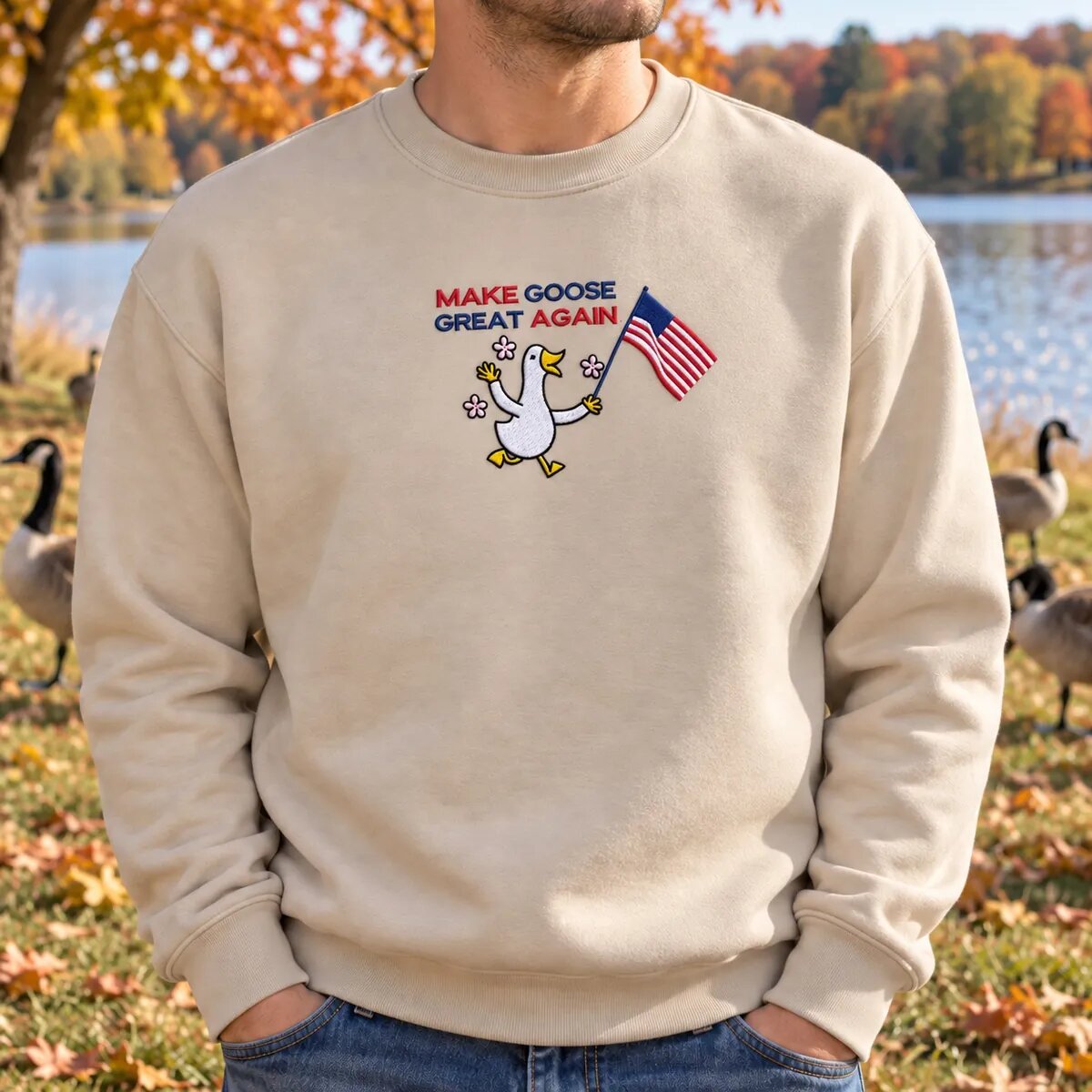 Man Wearing the Make Goose Great Again Sweatshirt Man in a Sand Make Goose Great Again sweatshirt by a lake with Canada geese behind him