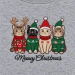 Close-up of the embroidered cats in Christmas sweaters, antlers and Santa hats above the Meowy Christmas script