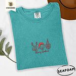 Seafoam Comfort Colors T-shirt embroidered with three red line-art dog faces in Christmas hats above Merry Woofmas script