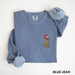 Blue Jean crewneck sweatshirt laid flat, embroidered with a small goldendoodle sitting in a red Santa hat
