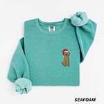 Seafoam crewneck sweatshirt laid flat, embroidered with a shaggy goldendoodle in a Santa hat on the left chest