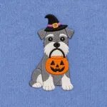 Close-up of the embroidered Miniature Schnauzer in a witch hat with a jack-o'-lantern candy bucket