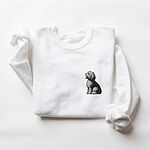 White crewneck sweatshirt laid flat on a white background, embroidered with a shaggy Old English sheepdog sitting in profile with a white front, a dark back and a red tongue on the left chest