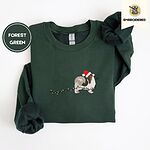 Forest Green crewneck sweatshirt folded on a white background, embroidered with a tricolor Papillon in a Santa hat holding the plug of a string of Christmas lights in its mouth