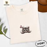 Ivory Comfort Colors T-shirt embroidered with a fluffy brown tabby kitten peeking over a ledge at a pink butterfly