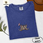 True Navy Comfort Colors T-shirt embroidered with a fluffy brown tabby kitten peeking over a ledge at a pink butterfly
