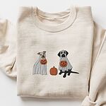 Sand crewneck sweatshirt laid flat with a rolled cuff, embroidered with a pit bull and a black lab in ghost sheets holding jack-o'-lantern buckets