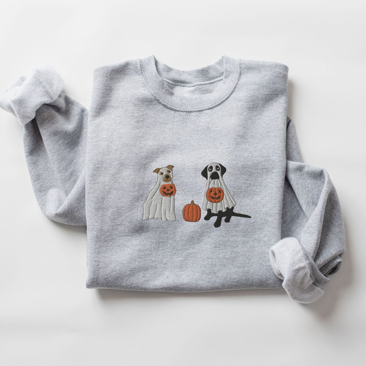 Pitbull and Black Lab Sweatshirt - Sport Grey Sport Grey crewneck sweatshirt laid flat on a white background, embroidered with a pit bull and a black lab in ghost sheets holding jack-o'-lantern buckets