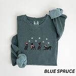 Blue Spruce crewneck sweatshirt laid flat with a rolled cuff, embroidered with four black pitbull silhouettes in a Santa hat, striped scarves and a knit hat under snowflakes