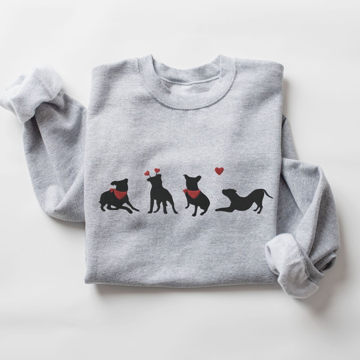 Pitbull Valentine Sweatshirt - Sport Grey Sport Grey crewneck sweatshirt laid flat, embroidered with four black pitbull silhouettes with red bandanas, a red heart headband and a floating red heart