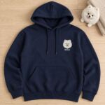 Navy hoodie with a small embroidered white Pomeranian face and the name Mochi on the left chest