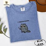 Blue Jean Comfort Colors T-shirt embroidered with a feral raccoon holding a little knife under the words i require snacks embroidered on the chest