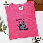 Crunchberry Comfort Colors T-shirt embroidered with a feral raccoon holding a little knife under the words i require snacks embroidered on the chest
