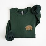 Forest Green crewneck sweatshirt laid flat on white, embroidered with a red dachshund face with long floppy ears, round black eyes and a little smile on the left chest