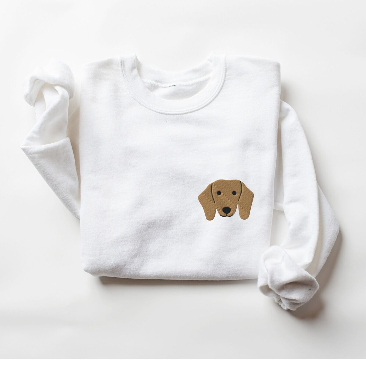 Red Dachshund Sweatshirt - White White crewneck sweatshirt laid flat on white, embroidered with a red dachshund face with long floppy ears, round black eyes and a little smile on the left chest