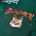 Reindeer cat sweatshirt with an orange cat portrait, red nose, varsity name lettering and EST year