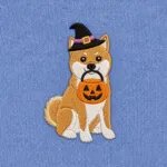 Close-up of the embroidered Shiba Inu in a witch hat with a jack-o'-lantern candy bucket