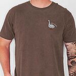 Man in an Espresso brown T-shirt embroidered with a white goose and the words silly dada in white thread