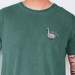 Silly dada shirt in Light Green worn by a man, embroidered with a little white goose with the words silly dada arched over its back on the left chest
