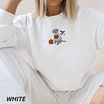 Woman in a White crewneck sweatshirt embroidered with a silver Labrador under a ghost sheet with an orange pumpkin and three black bats