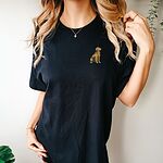 Woman in a Black T-shirt embroidered with a small sitting golden retriever on the left chest
