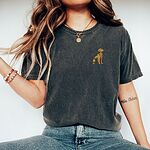 Woman in a Pepper T-shirt and jeans, embroidered with a small sitting golden retriever on the left chest